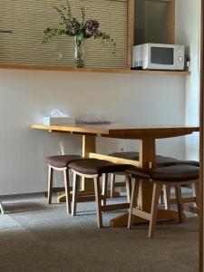 a table with two chairs and a table with a microwave at Hostel Mt. Fuji - FUKUYA in Fujiyoshida