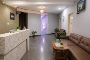 a lobby with a couch and a table and a bar at Hotel Golden Suites in Bangalore