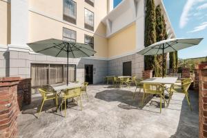 a patio with tables and chairs and umbrellas at Hampton Inn Harbourgate in Myrtle Beach