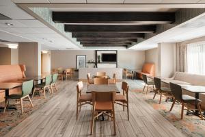 a waiting room with tables and chairs in an office at Hampton Inn Harbourgate in Myrtle Beach