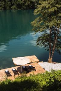 a dock with a table and chairs on the water at Zen Emerald Resort & Spa, Soča river in Most na Soči