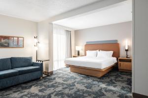 a hotel room with a bed and a couch at Hampton Inn Harbourgate in Myrtle Beach +35 photos