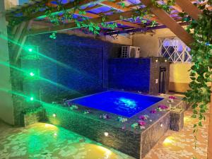 a hot tub in the middle of a room with lights at Hébergement H in Ngaring