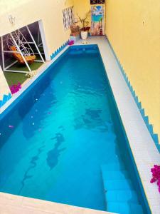 a swimming pool in a house with blue water at Hébergement H in Ngaring