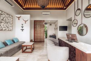 a living room with a couch and a table at Aksari Villa Seminyak by Ini Vie Hospitality in Seminyak +25 photos