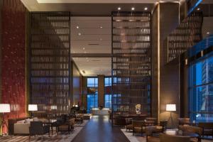 a lobby with a library with tables and chairs at Hyatt Regency Shanghai Wujiaochang in Shanghai