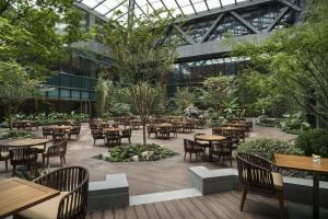 an outdoor patio with tables and chairs in a building at Hyatt Regency Shanghai Wujiaochang in Shanghai