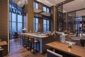 a bar in a restaurant with tables and chairs at Hyatt Regency Shanghai Wujiaochang in Shanghai