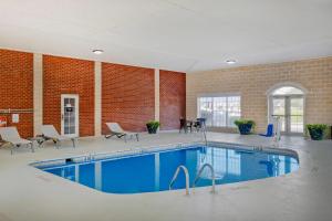 a large pool in a building with chairs and tables at Comfort Suites Sumter near Shaw AFB in Sumter