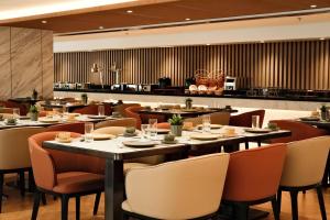 a restaurant with tables and chairs in a room at Wyndham Garden Manila Bay in Manila