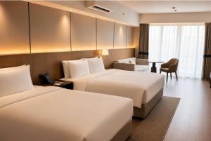 a hotel room with two beds and a table at Wyndham Garden Manila Bay in Manila +53 photos