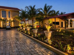 a cobblestone street in front of a house with palm trees at Mangalam Resort & Spa - Member of Absolute Collection in Aurangabad