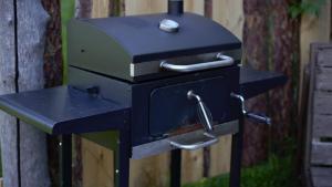 a black grill sitting next to a wooden fence at Uneallika puhkemaja-külalistemaja in Pae
