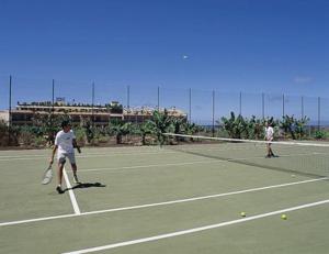 two people playing tennis on a tennis court at Hotel Gran Rey in Valle Gran Rey