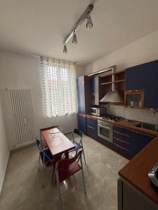 a kitchen with blue cabinets and a table and chairs at Casa Mane in Avezzano +12 photos