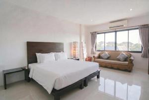 a bedroom with a large white bed and a couch at Wilacha Chiang Rai in Chiang Rai +65 photos