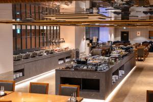 a restaurant with a long counter with tables and chairs at Best Western Jeju Hotel in Jeju