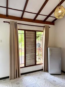 a kitchen with a refrigerator and a window at Soulinn Regina Weligama in Weligama