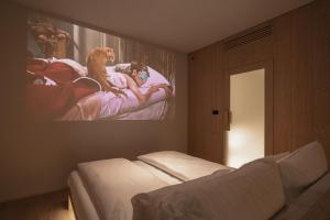 a bedroom with a bed with a painting on the wall at Zen Emerald Resort & Spa, Soča river in Most na Soči