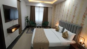 a hotel room with a bed and a flat screen tv at Hotel Preeti Residency Delhi in New Delhi
