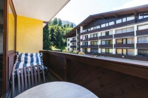 a balcony with a table and a chair and a building at Studio 28 Kaprun inkl Sommerkarte in Kaprun