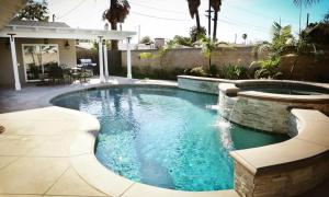 a swimming pool with a fountain in a yard at Fantastic 6 bedroom, 4 & Half bath home (4 master Suites), pool home in Anaheim