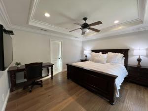 a bedroom with a bed with a ceiling fan and a desk at Fantastic 6 bedroom, 4 & Half bath home (4 master Suites), pool home in Anaheim