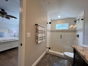 a bathroom with a shower and a toilet and a bed at Fantastic 6 bedroom, 4 & Half bath home (4 master Suites), pool home in Anaheim +21 photos