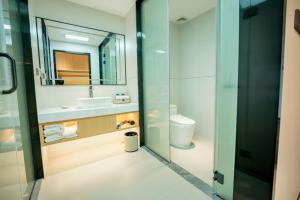a bathroom with a sink and a toilet and a mirror at 玉恒酒店 in Sihui +17 photos