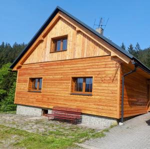 a wooden building with a bench in front of it at Chalupa Pavlonka in Staré Hamry
