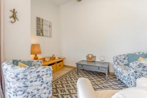 a living room with two chairs and a table at Gîte le Petit Luberon - Lisianthus in Cabrières-dʼAvignon