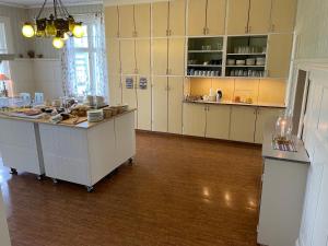 a kitchen with white cabinets and a large island at Trunnagården in Orsa +77 photos