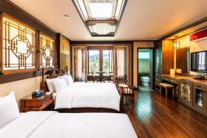 a hotel room with two beds and a television at Jeju Nine resort in Jeju