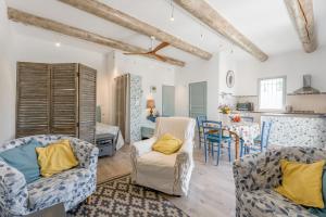 a living room with two chairs and a table at Gîte le Petit Luberon - Lisianthus in Cabrières-dʼAvignon