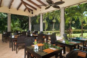 a restaurant with tables and chairs and large windows at Occidental Papagayo ALL INCLUSIVE-Adults Only in Culebra