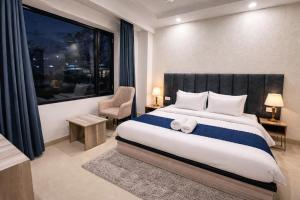 a bedroom with a bed and a chair and a window at Hotel LA Costa Managed By Sitara Group in Haridwār