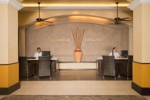 two people sitting at tables in a hotel lobby at Occidental Papagayo - Adults Only All Inclusive in Culebra