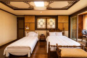 two beds in a room with two windows at Jeju Nine resort in Jeju +48 photos