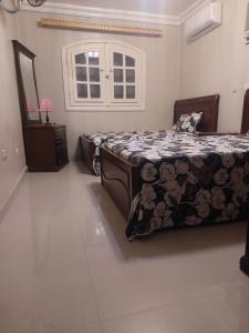 a bedroom with a bed and a dresser and a window at Marina 4 Guest House in El Alamein +18 photos