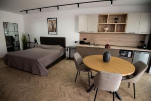a bedroom with a bed and a table and a kitchen at Incanto Rentals in Silistra