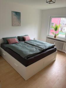 a bedroom with a large bed with pink pillows on it at Village Apartment Rheinbreitbach in Rheinbreitbach