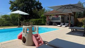 a swimming pool with an umbrella and a playground at Villa L'Hermitière - 4 étoiles in Oytier-Saint-Oblas