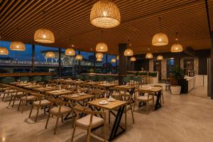 a restaurant with wooden tables and chairs and chandeliers at S by Z Hotels, HSR in Bangalore