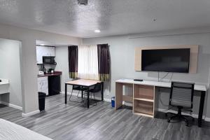 a hotel room with a desk and a television at Travelodge by Wyndham Redding CA in Redding