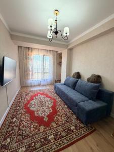 a living room with a blue couch and a red rug at vzmorie apart in Bosteri