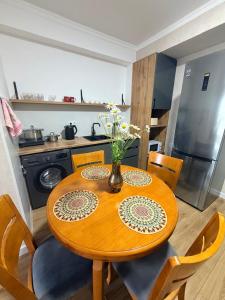 a kitchen with a wooden table with a vase of flowers on it at vzmorie apart in Bosteri