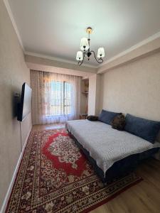 a bedroom with a large bed and a rug at vzmorie apart in Bosteri