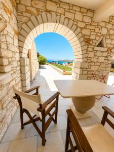 a patio with an archway and a table and chairs at Avgerinos Village in Agiassos