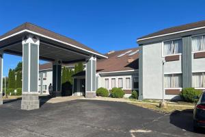 a large white building with a parking lot at Quality Inn Plainfield I-395 in Plainfield