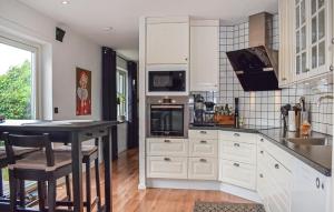 a kitchen with white cabinets and a black counter top at 4 Bedroom Lovely Home In Simrishamn in Simrishamn +18 photos